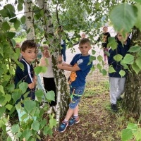 Uczniowie klas młodszych przytulający się do drzew. (5)